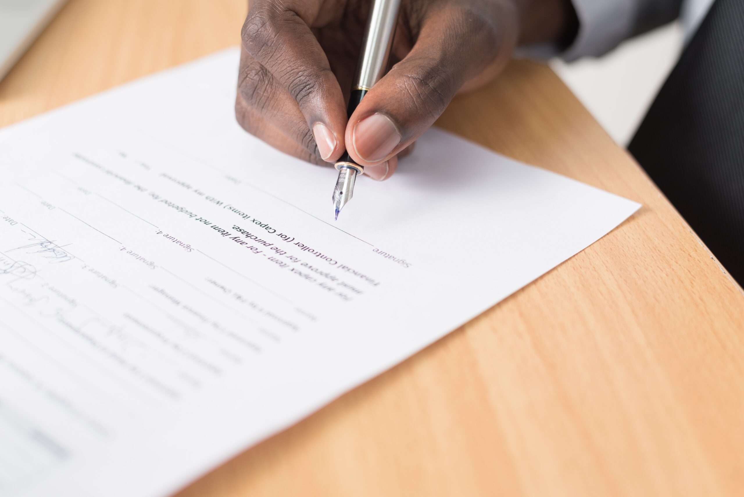 close up of a hand signing a document representing a last will