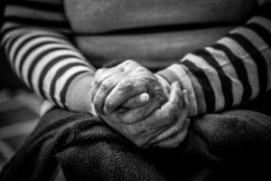An older woman's hands clasped, representing an elderly woman at the center of a power of attorney dispute
