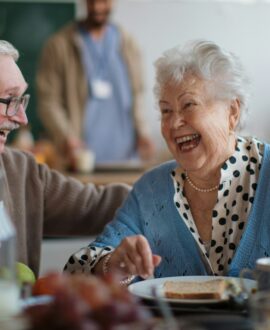 A senior man and woman laughing while eating, representing substitute decision-making in Ontario