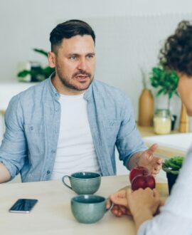 Two young adults arguing at a kitchen table, representing inheritance disputes in Ontario