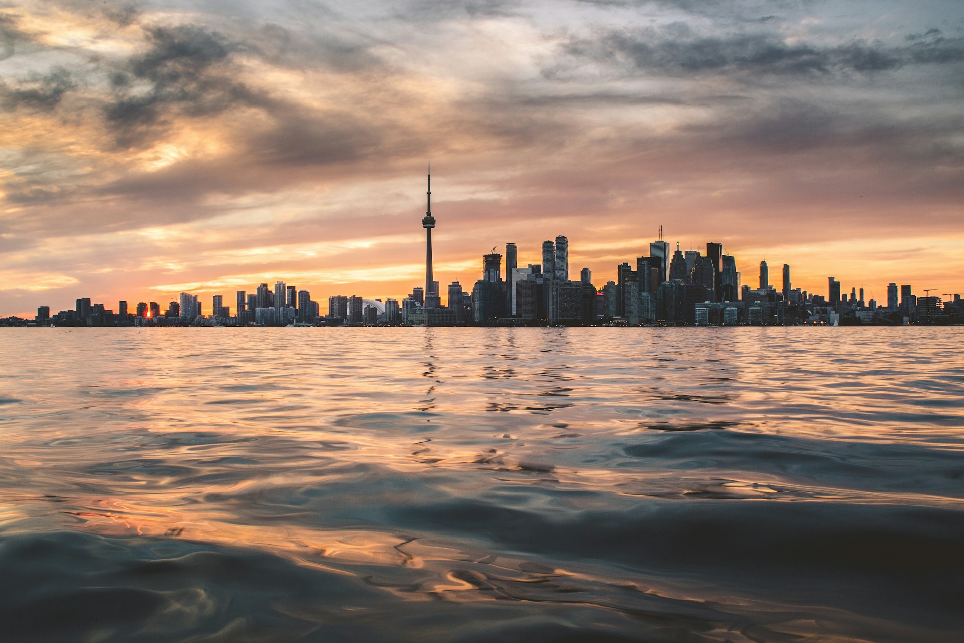 The Toronto skyline, featuring the CN Tower, silhouetted against a sunset with Lake Ontario in the foreground, representing Best Lawyers.