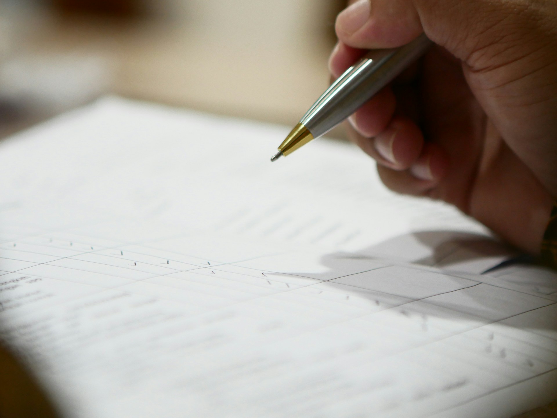 A hand holds a pen over a stack of blurred documents, representing discretionary trusts in Ontario.